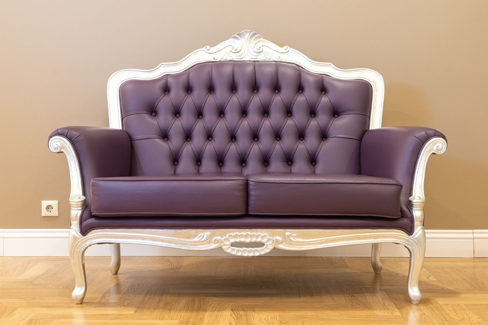Altes Ledersofa mit geknöpfter Polsterung und verziertem Rahmen
